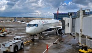 Delta Air Lines Airbus A220-300 at the gate before a Delta Comfort review flight, showing the aircraft exterior and boarding area.