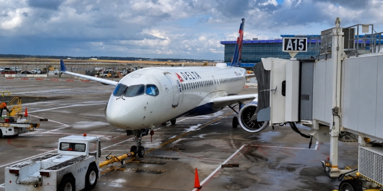 Delta Air Lines Airbus A220-300 at the gate before a Delta Comfort review flight, showing the aircraft exterior and boarding area.