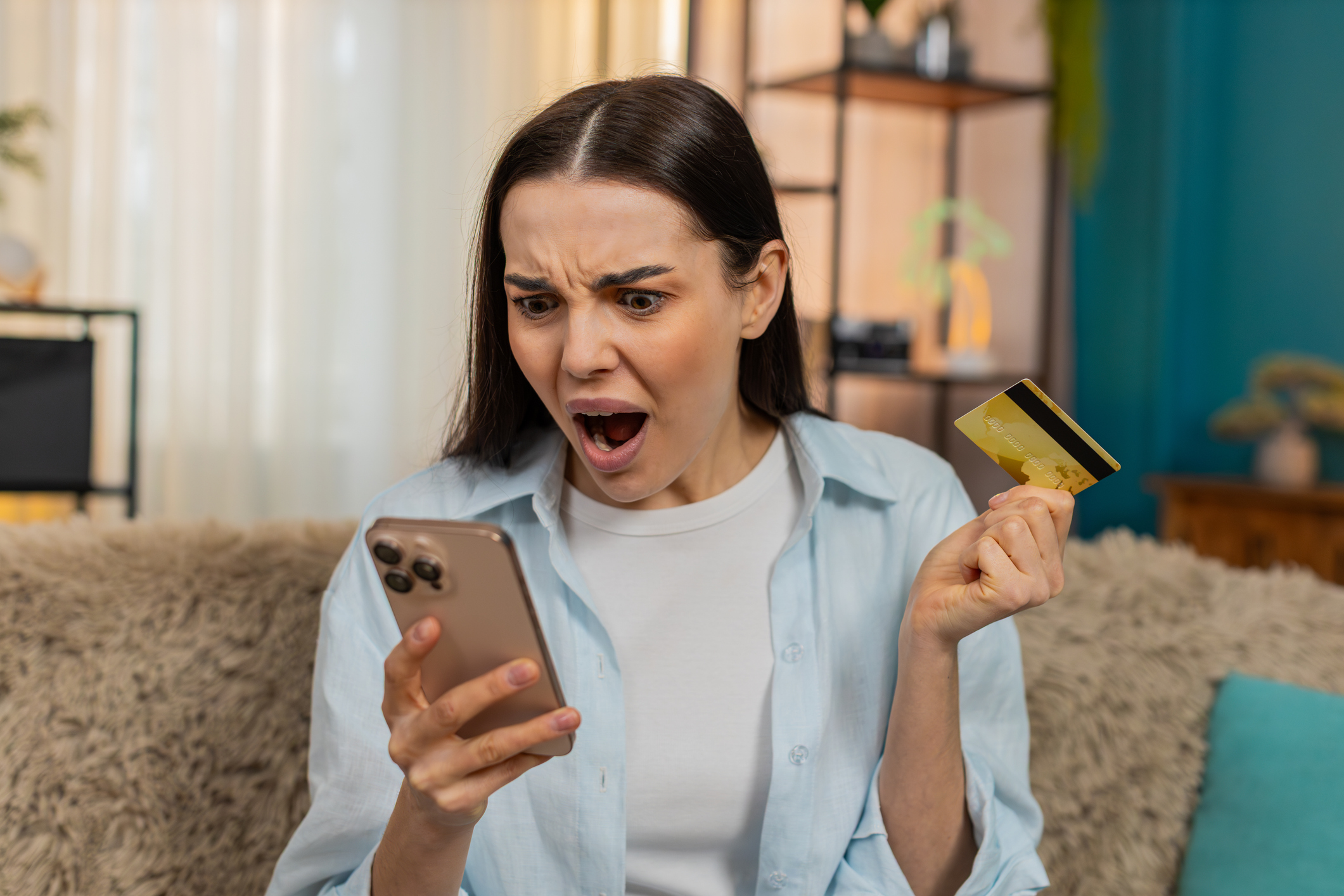 Woman worried while checking her credit card balance on her phone