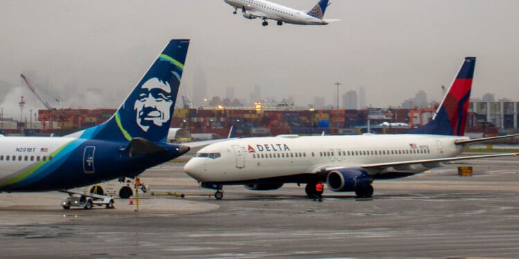 Delta Air Lines Boeing 737-832 aircraft registered as N3752 being towed to gate near parked Alaska Airlines Boeing 737-9 Max aircraft N291BT at Newark Liberty International Airport in April 2022. (©iStock.com/kameraworld)